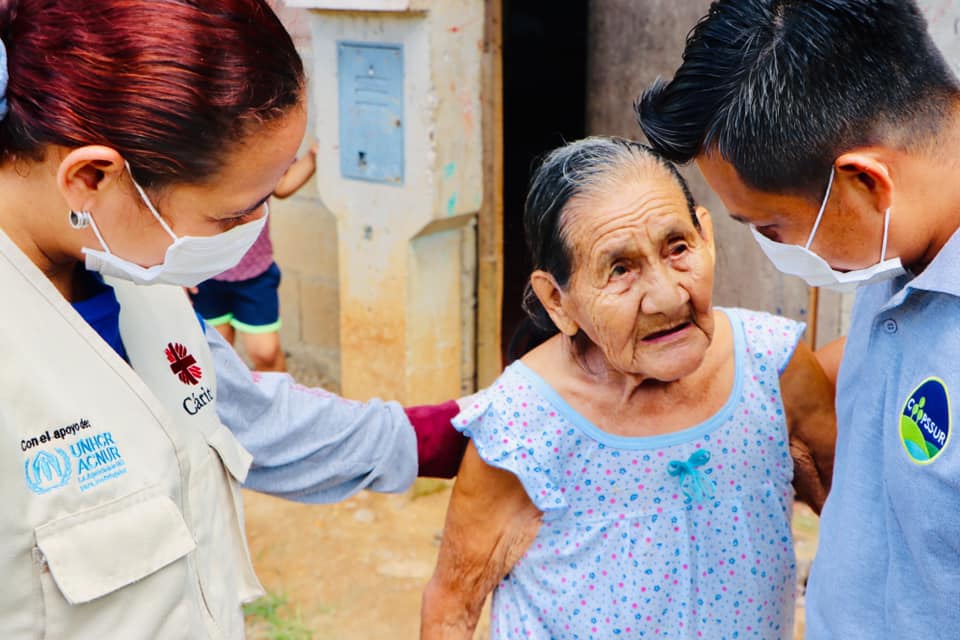 Personal de Cáritas, durante entrega a una anciana identificada como vulnerable en la zona periférica de Puerto Maldonado. Foto: Cáritas Madre de Dios
